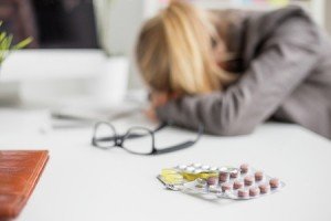 46693488 - woman sleeping on desk after taking pills